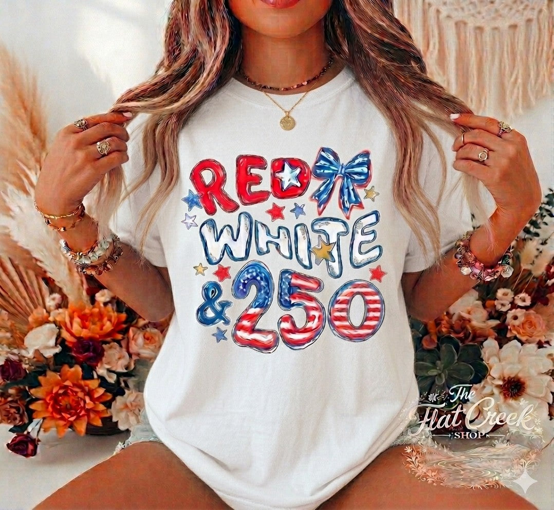 Two hundred and fifty years of freedom — and we're still celebrating. This bold patriotic graphic tee features retro-style lettering, stars, a firecracker, and a coquette bow on a classic pink stripe flag design. The perfect way to rep your American pride with a fun, feminine twist.