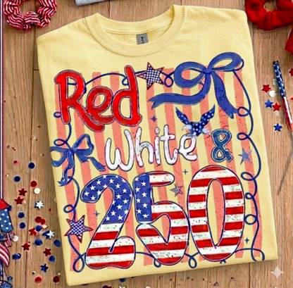 Yellow t-shirt with red, white, and blue design on a wooden surface with festive decorations.